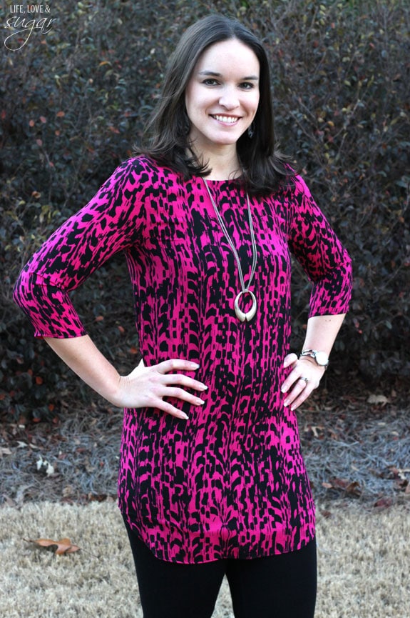 Author posing in a pink and black printed tunic top