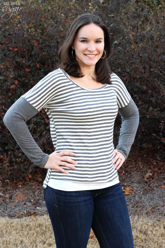 Author posing in a gray and white striped top