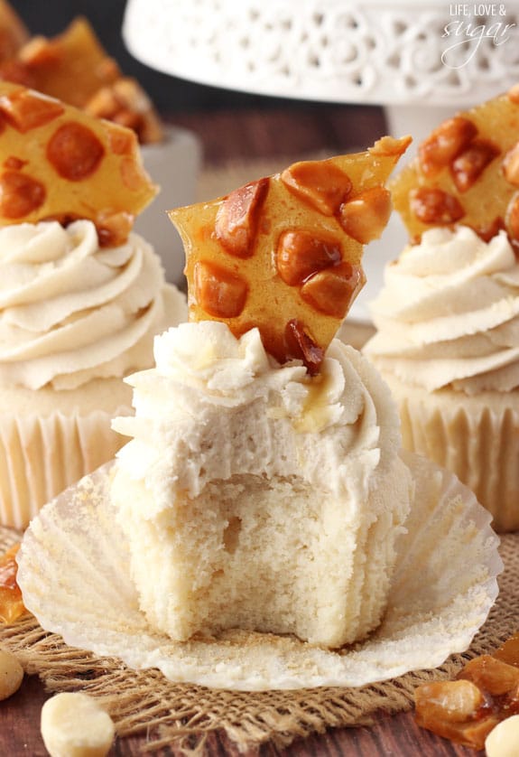 A Macadamia Brittle Cupcake that has it's wrapper pealed off and a bite taken out