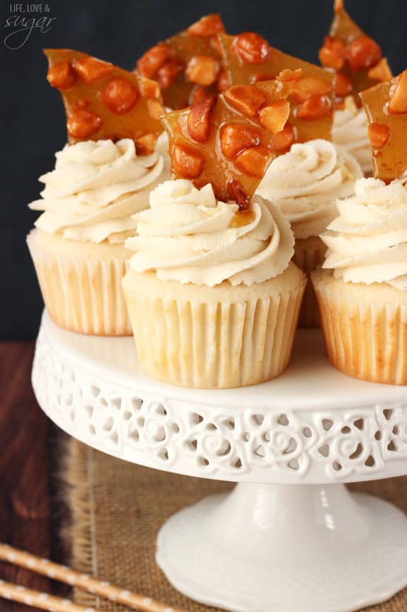 A bunch of BAILEYS® Macadamia Brittle Cupcakes on top of a white cake stand