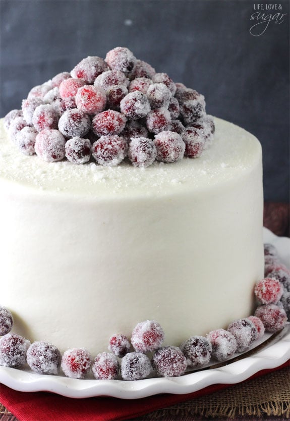 Sparkling Cranberry White Chocolate Cake - super moist vanilla cake full of fresh cranberries, iced with white chocolate icing and topped with sparking cranberries!