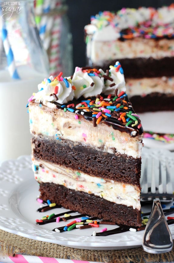 A slice of fudge brownie cake batter layer cake on a plate with a metal fork