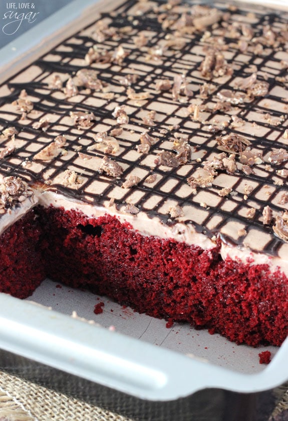 Nutella Red Velvet Poke Cake in a 9x13 pan with a couple squares removed