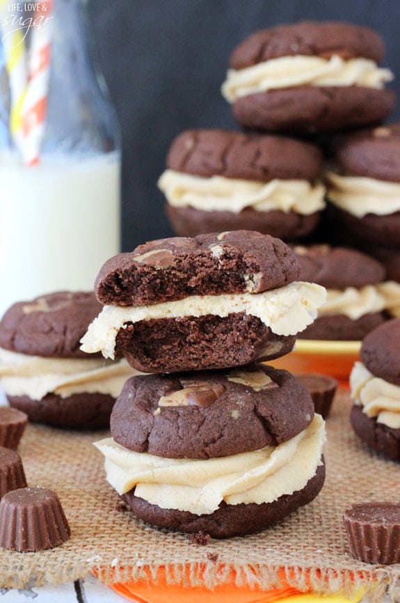 Two chocolate cookie sandwiches are stacked and the top one has a bite taken out of it