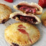 Strawberry Nutella Hand Pies on wax paper, one pie halved