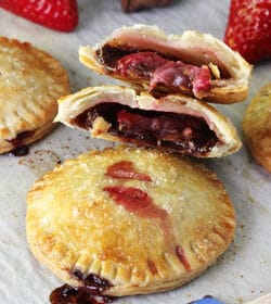 Strawberry Nutella Hand Pies on wax paper, one pie halved
