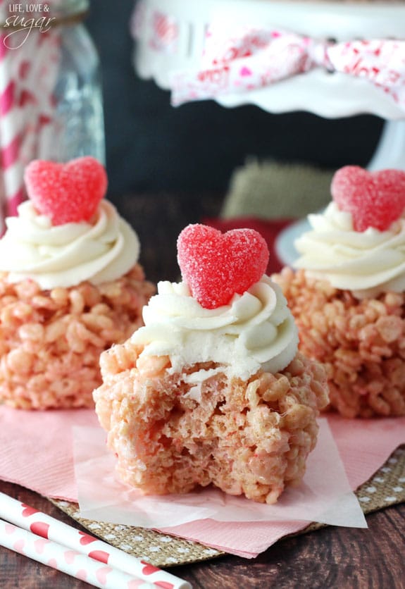 A Rice Krispie Treat Cupcake with a bite missing on pink napkin