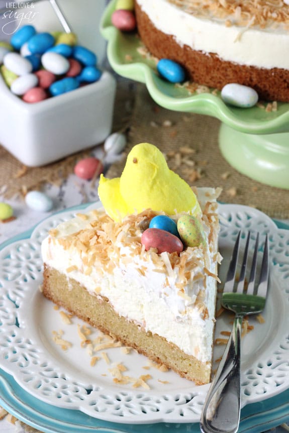 Coconut Blondie Cheesecake slice on a plate topped with a marshmallow peep and easter egg candies