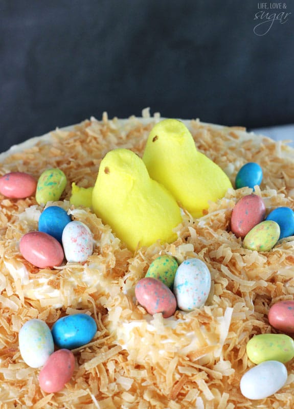 Close-up of Coconut Blondie Cheesecake topped with marshmallow peeps and easter egg candies