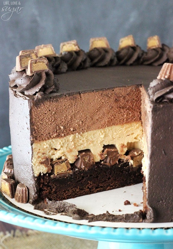 Peanut Butter Chocolate Mousse Cake on a blue cake stand with a slice removed
