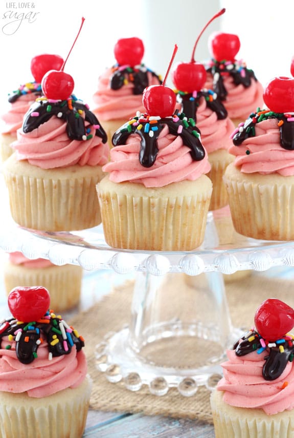 Strawberry Sundae Cupcakes on a clear glass cake stand