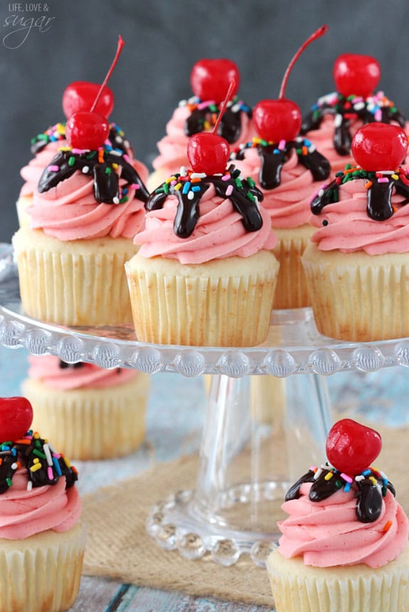 Strawberry Sundae Cupcakes on a clear glass cake stand