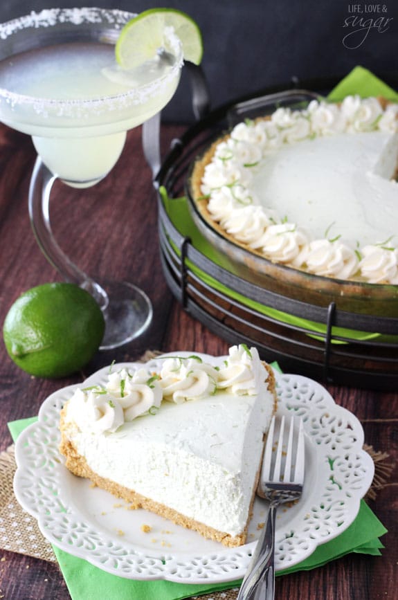No Bake Margarita Pie slice on a plate in front of a margarita and the whole pie