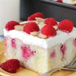 Raspberry Almond Poke Cake slice on yellow plate