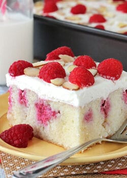 Raspberry Almond Poke Cake slice on yellow plate