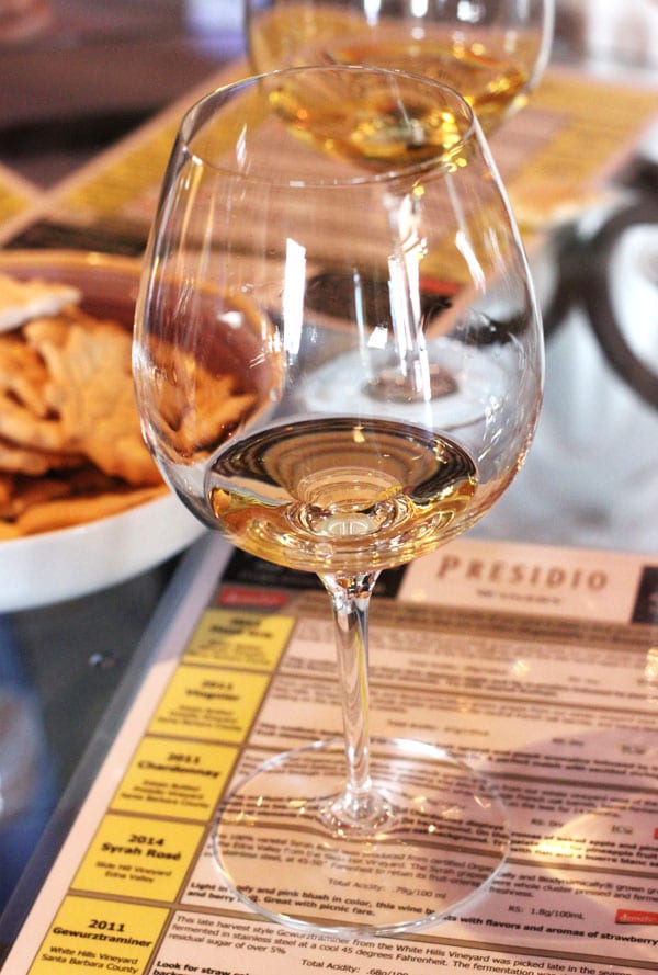 A Glass of White Wine on Top of a Laminated Prisidio Menu