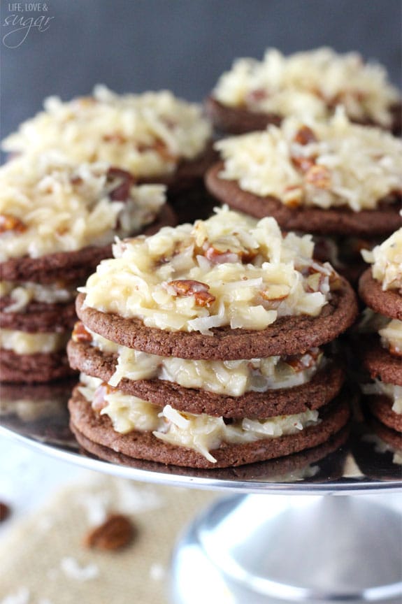 Close up of a Stack of German Chocolate Cookies with coconut pecan frosting between them on a silver platter