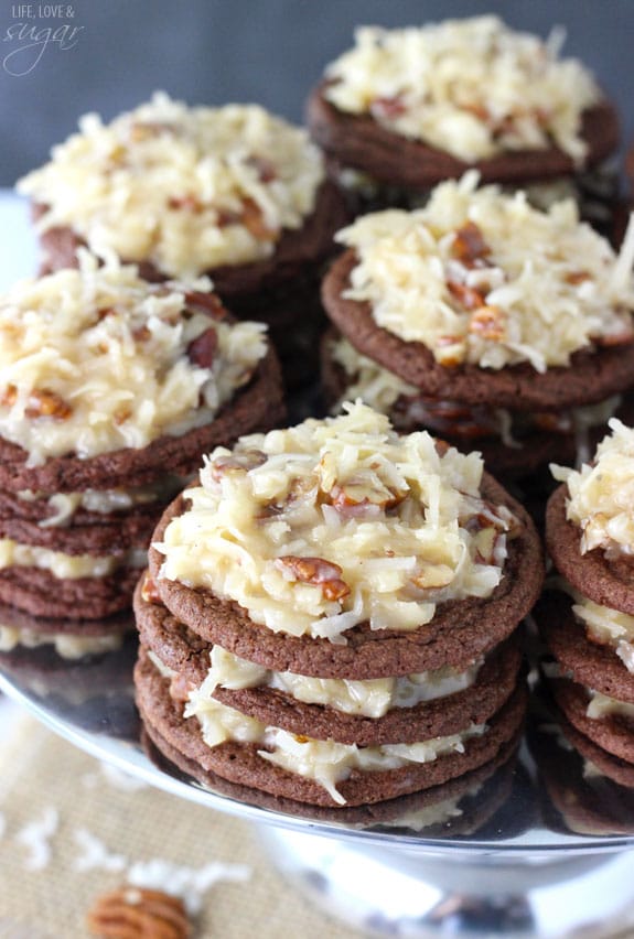 Stacks of German Chocolate Cookies with coconut pecan frosting on a silver platter