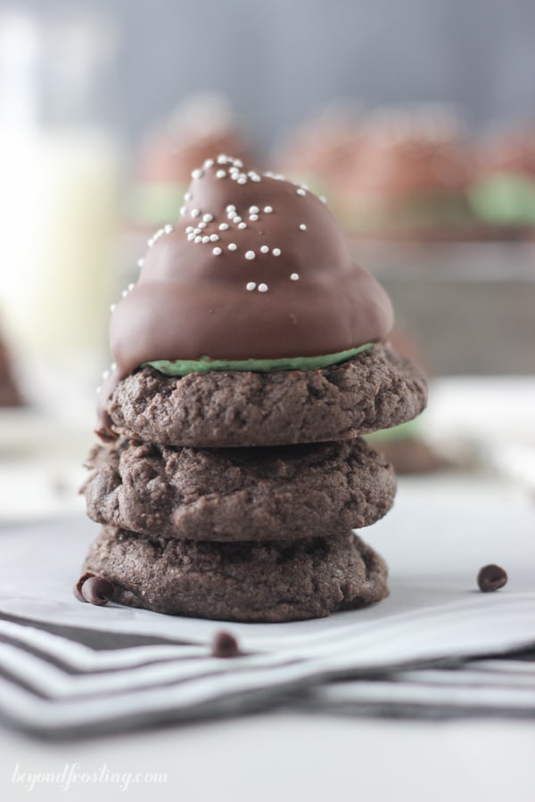 Close-up of a Mint Chip Hi Hat Cookie stacked on top of chocolate cookies