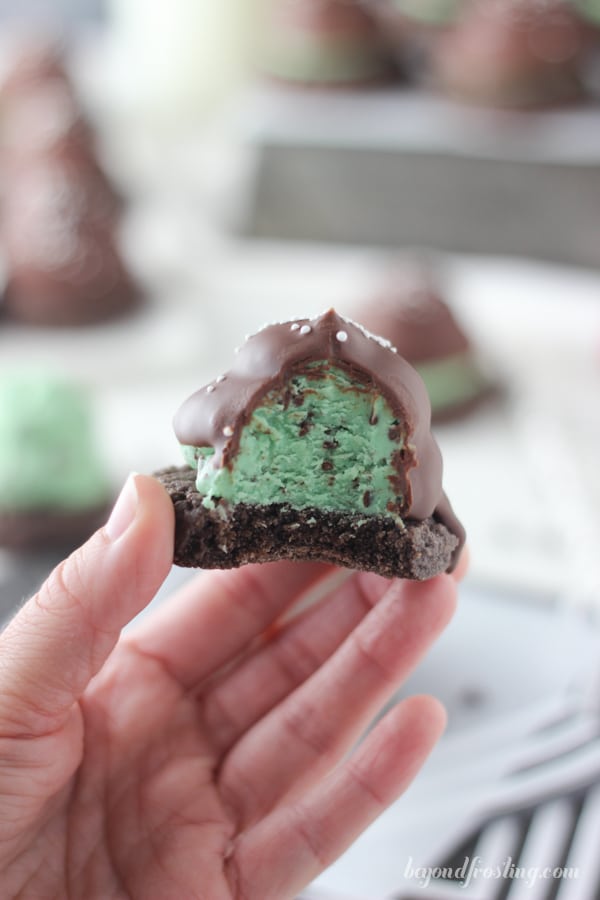 A hand holding a Mint Chip Hi Hat Cookie with a bite out of it