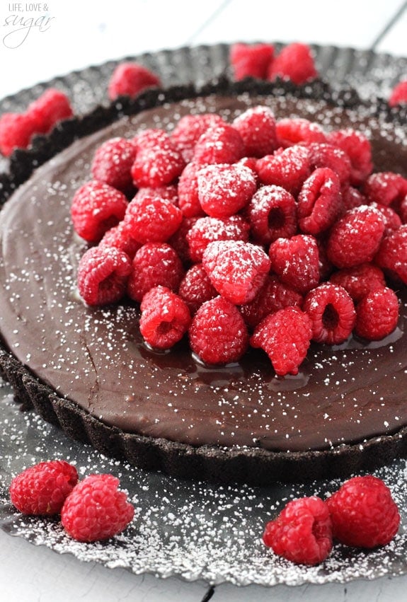 Nutella Raspberry Tart topped with sugar coated fresh raspberries and powdered sugar