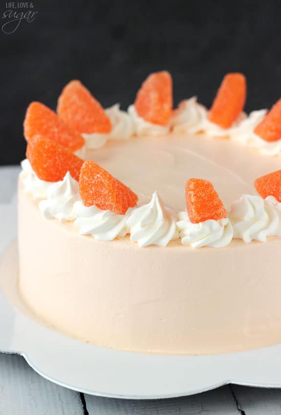 Orange Creamsicle Ice Cream Cake topped with swirls of whipped cream and candied oranges