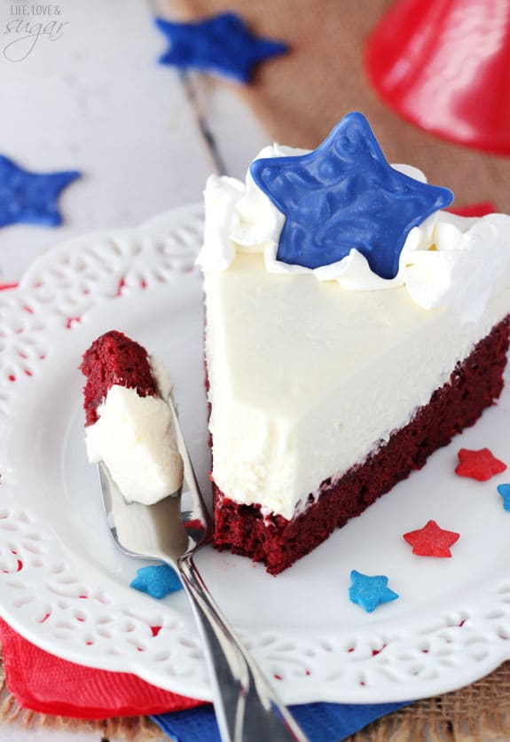 Red Velvet Blondie Cheesecake slice topped with a blue star on a plate and a bite on a fork