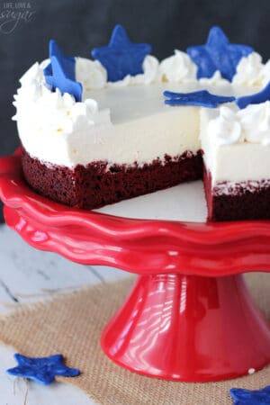 Red Velvet Blondie Cheesecake on red stand with slice missing