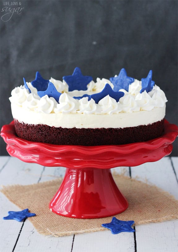 Red Velvet Blondie Cheesecake on a red cake stand topped with blue stars