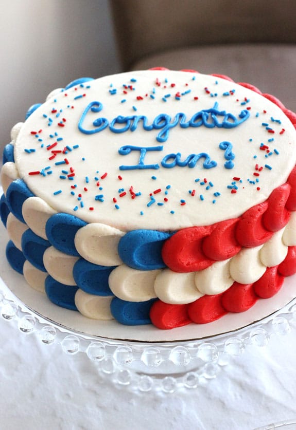 Red, white, and blue cake with Congrats Ian text on top