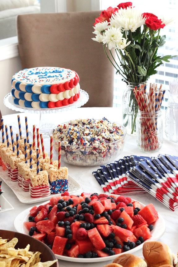 A table of patriotic food, napkins, and flowers