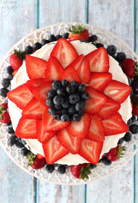 Fresh Berry Vanilla Layered Cake - layers of moist vanilla cake flavored with pureed strawberries and blueberries, layered with fresh berries and whipped cream! #pictureperfectplate