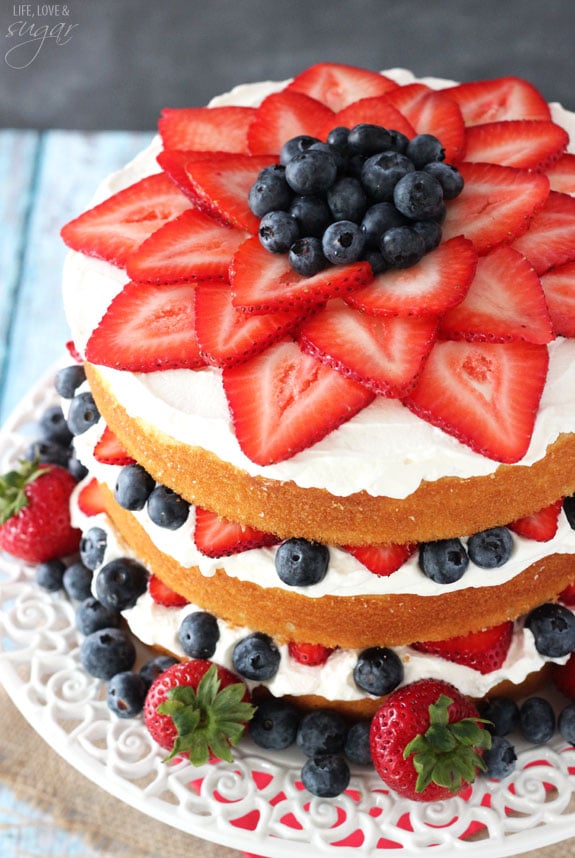 Fresh Berry Vanilla Layered Cake - layers of moist vanilla cake flavored with pureed strawberries and blueberries, layered with fresh berries and whipped cream! #pictureperfectplate