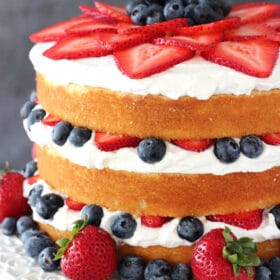 A Fresh Berry Vanilla Layered Cake on a White Cake Stand