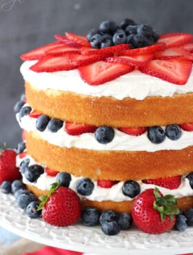 A Fresh Berry Vanilla Layered Cake on a White Cake Stand