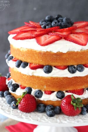 A Fresh Berry Vanilla Layered Cake on a White Cake Stand