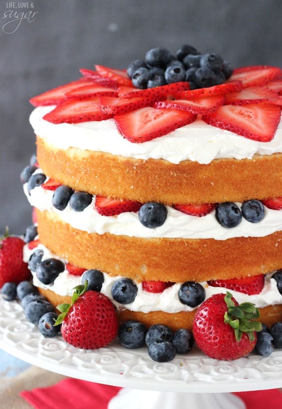 A Fresh Berry Vanilla Layered Cake on a White Cake Stand