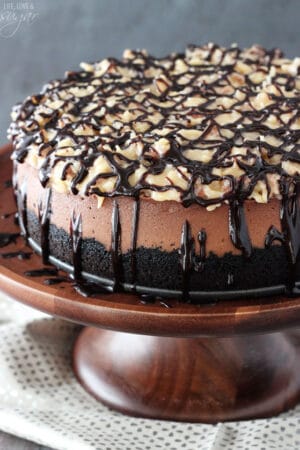 A whole German Chocolate Cheesecake on a wooden stand