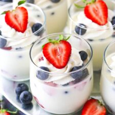 close up of glass cup of panna cotta with berries in it