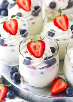 close up of glass cup of panna cotta with berries in it