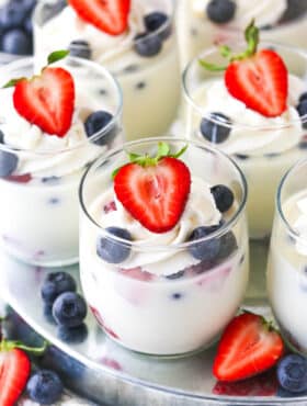 close up of glass cup of panna cotta with berries in it