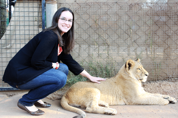 Lindsay Petting a Lion Cub and Smiling at the Camera