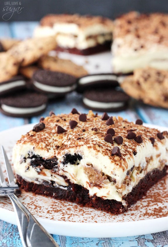 A slice of tiramisu on a plate with cookies behind it.