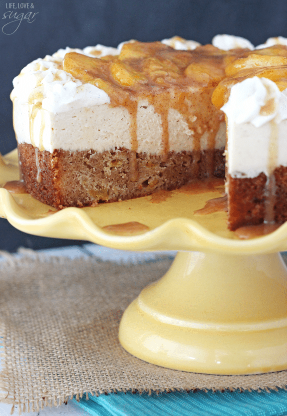 Peach Caramel Blondie Cheesecake on a yellow cake stand with a slice removed