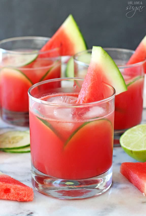 Side view of Watermelon Elderflower Cocktail garnished with cucumber slices and a watermelon wedge