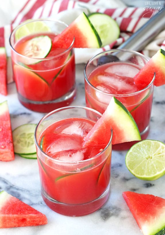 Watermelon Elderflower Cocktail in rocks glasses garnished with watermelon wedges and cucumber slices