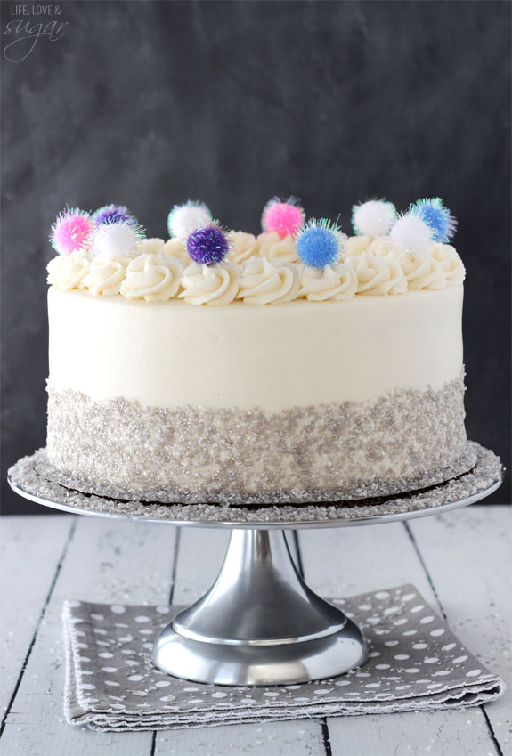 Side view of Sparkly Pom Pom Cake on a silver cake stand