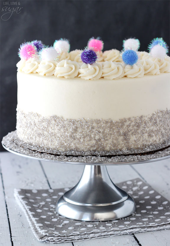 Side view of Sparkly Pom Pom Cake on a silver cake stand