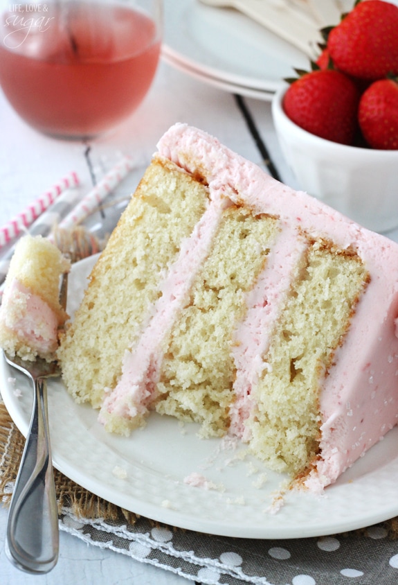 Strawberry Moscato Layer Cake slice on a plate with a bite on a fork