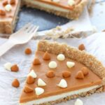 A big slice of White Chocolate Butterscotch Tart on white paper and a fork